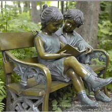 garçon et fille de bronze assis sur une sculpture de banc